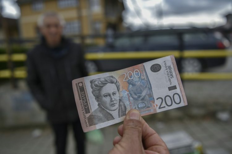 A street vendor with a Serbian dinar banknote in Gracanica, Kosovo . ©AFP