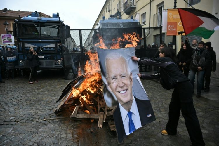 Activists burn a portrait of US President Joe Biden and G7 leaders during a demonstration against the G7 Climate, Energy and Environment held in Turin, on April 28. ©AFP