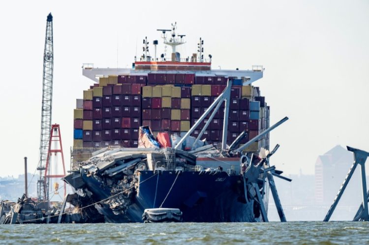 A section of the Francis Scott Key Bridge rests in the water next to the Dali container ship in Baltimore on May 13, 2024, after crews conducted a controlled demolition. ©AFP