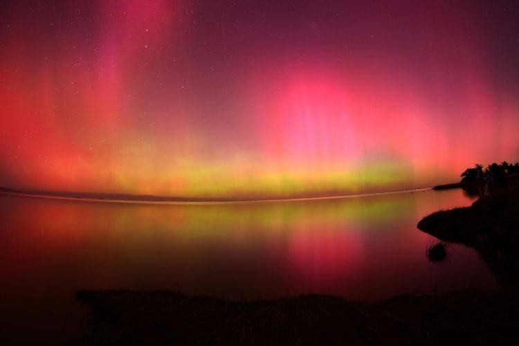 The Aurora Australis, also known as the Southern Lights, glows over Lake Ellesmere outside Christchurch in New Zealand after the most powerful solar storm in more than two decades. ©AFP