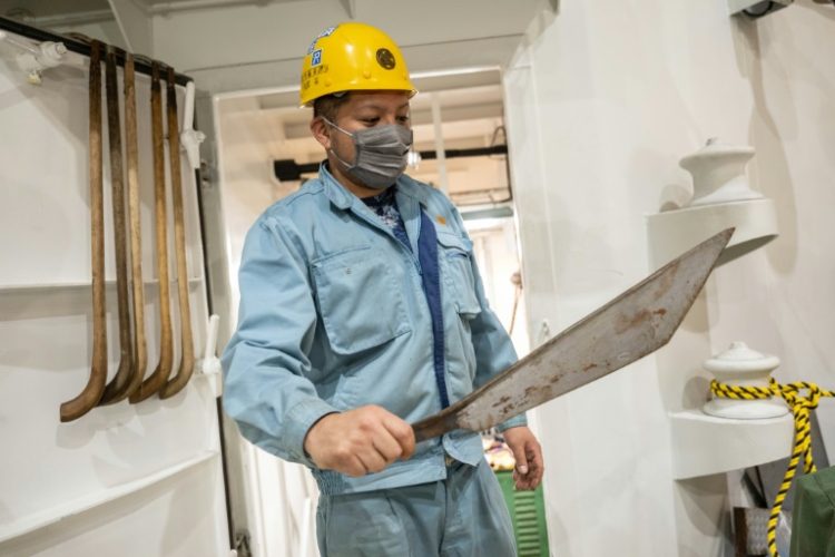 A crew member shows a large knife for cutting up whales on Japan's new whaling mothership, the Kangei Maru. ©AFP