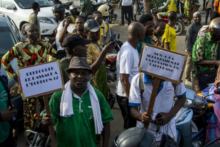 Demonstrators hold up placards during a march against the high cost of living in Cotonou, last April 27, 2024. ©AFP