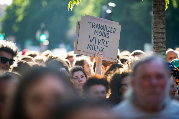 Markets are on edge amid campaigning in France with supporters holding a placard which reads 'Work less, Live better', as they attend a rally in Marseille in support of the Nouveau Front Populaire coalition. ©AFP