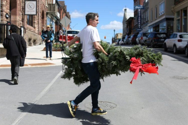 A set decorator carries a Christmas tree during filming of 'Hocus Pocus Christmas' on April 16 in Almonte, Ontario, just outside Ottawa. ©AFP