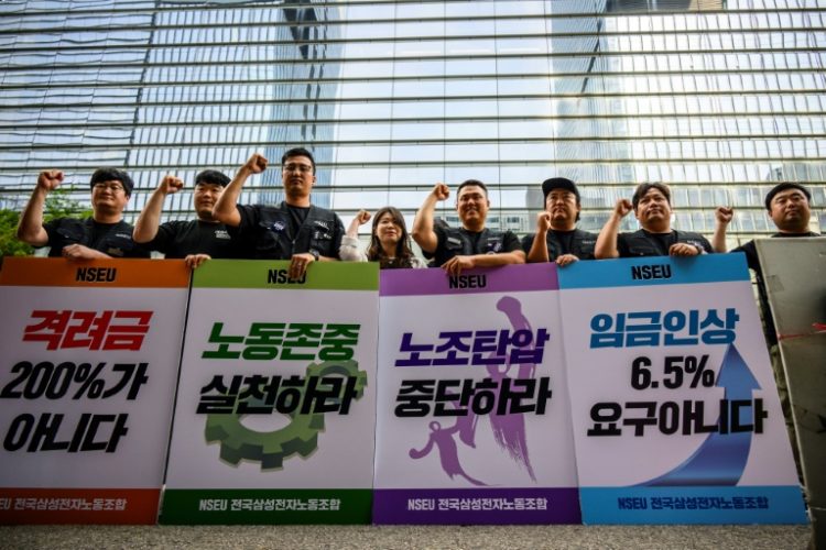 Samsung Electronics' union members hold placards during a rally outside the company building in Seoul . ©AFP