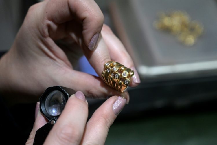 An appraiser examines a gold ring at a jewelry exchange in Buenos Aires. ©AFP