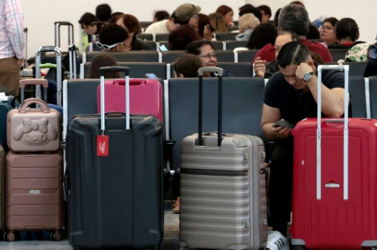 Passengers crowded into airports to wait for news as dozens of flights were cancelled. ©AFP