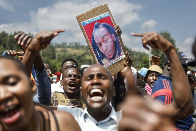 Family, friends and fellow protesters carry a photo of Rex Masaiwho was shot by the police . ©AFP