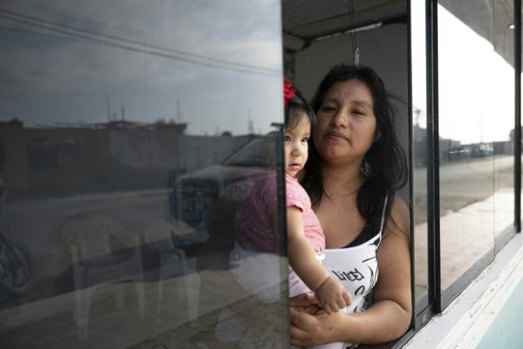 Sayuri Moreno, 37, and her daughter Valeria pose for a picture at their home in Huarmey. ©AFP