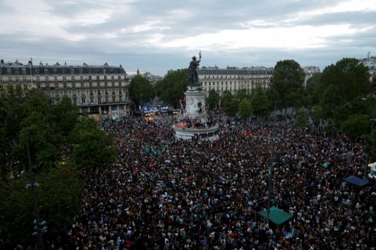 French people gather in Paris to await results of the second round of a snap election on Sunday evening. ©AFP