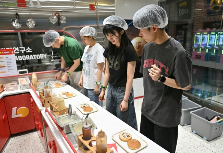 Visitors role play as researchers in a mock burger laboratory at an adults-only event at KidZania in Seoul. ©AFP