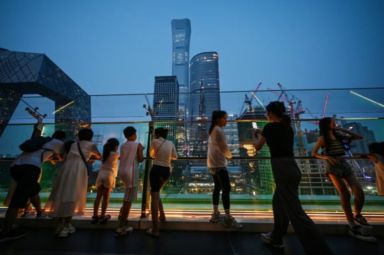 People look at buildings on the skyline from a viewing platform in a mall in Beijing’s central business district. ©AFP