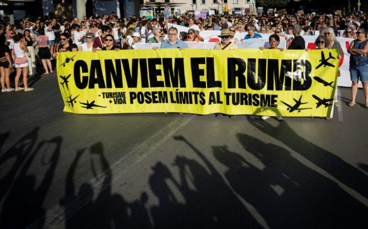 Protesters hold a banner which reads 'Let's change course' . ©AFP