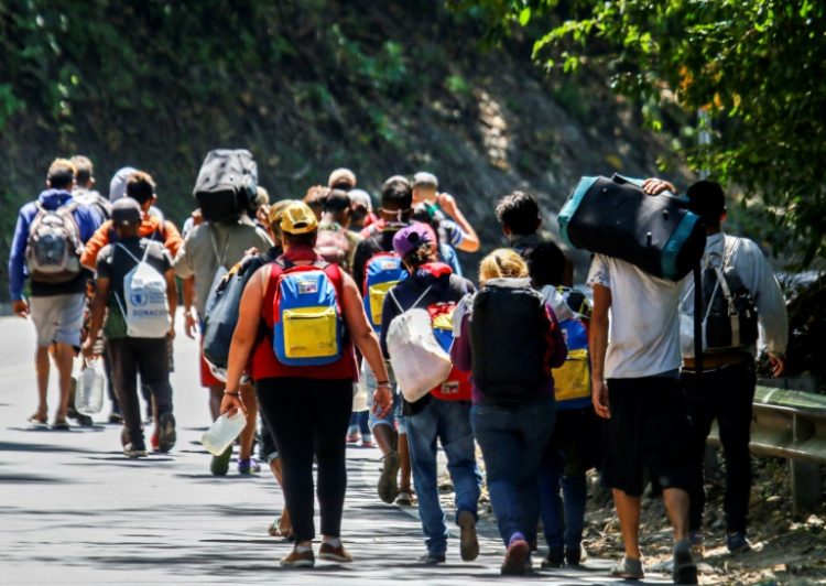 Venezuelan migrants walk along a road in Colombia in 2021. ©AFP