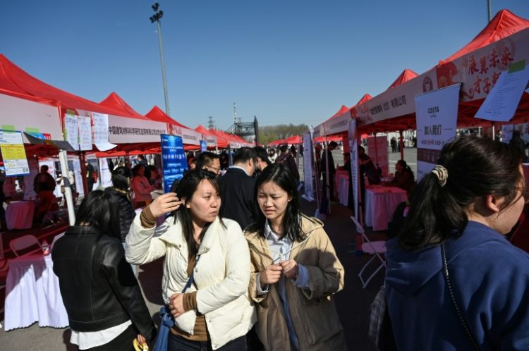 Young job seekers attend an employment fair in Beijing in March. ©AFP