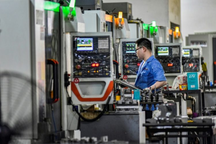 A worker on a production line at a printing and packaging factory in Qingzhou, eastern China. Manufacturing contracted for a fourth straight month in August, official data shows. ©AFP