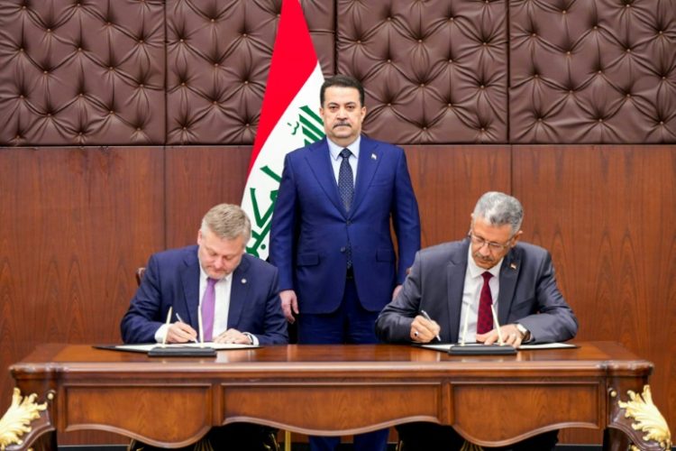 A picture released by the media office of Iraqi Prime Minister Mohamed Shia al-Sudani shows him  looking on as BP CEO, Murray Auchincloss (L) and Iraqi Oil Minister Hayan Abdul Ghani al-Sawad sign a memorandum of understanding to develop oil and gas fields in Kirkuk.. ©AFP