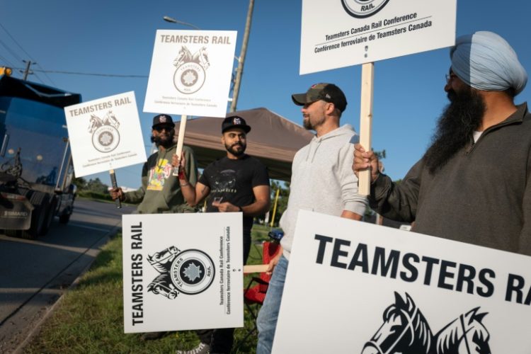 Locked out railway workers picket outside the CN Rail Brampton yard in Ontario province . ©AFP