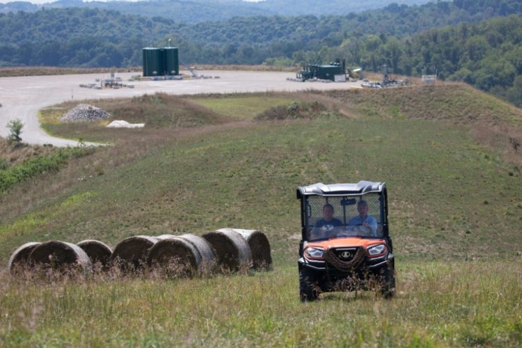 Diana Petrie, left, and her father George Wherry drive through hay fields after giving a tour of the natural gas well site on their farm in West Bethlehem Township, in Washington County, Pennsylvania. ©AFP