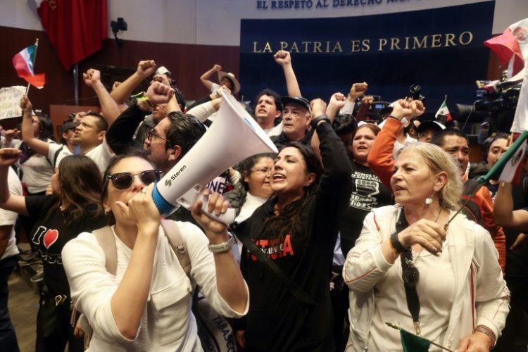 Demonstrators are seen inside Mexico's Senate after storming the building on September 10 to disrupt a debate on controversial judicial reforms. ©AFP