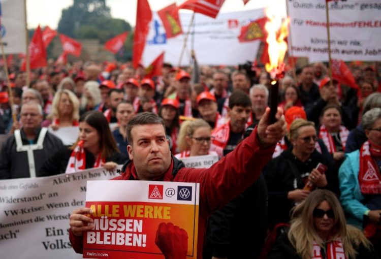 IG Metall metalworkers union members demonstrate in Hanover where talks between unions and Volkswagen management are to start . ©AFP