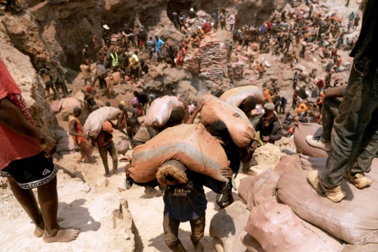 Artisanal miners carry sacks of ore at the Shabara artisanal mine in the Democratic Republic of Congo in October 2022. ©AFP