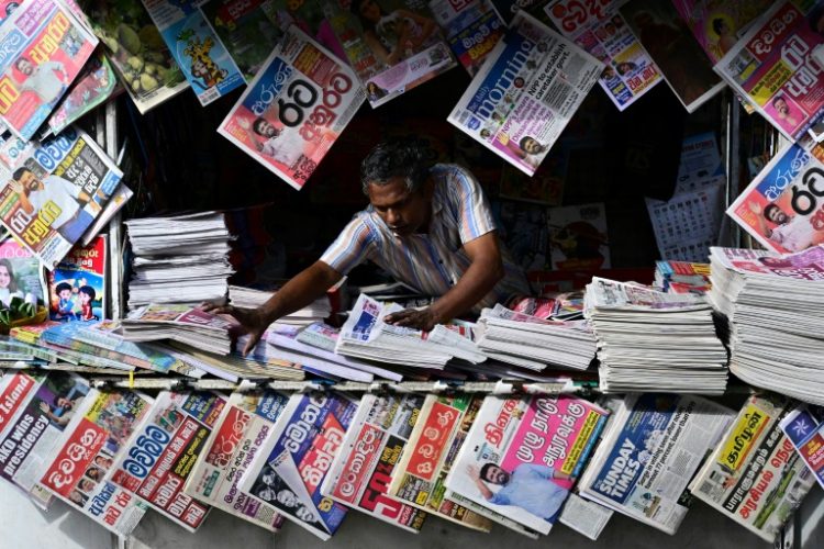 A Sri Lankan newspaper vendor arranges his display on the day the country's new president was sworn in. ©AFP