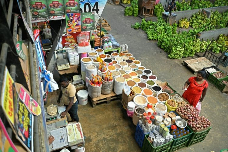 A woman buys groceries at a market in Colombo . ©AFP