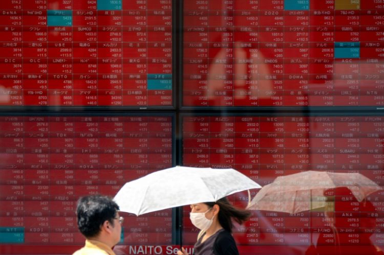 Pedestrians walk in front of an electronic quotation board displaying stock prices of Nikkei 225 on the Tokyo Stock Exchange in Tokyo on September 12, 2024. ©AFP