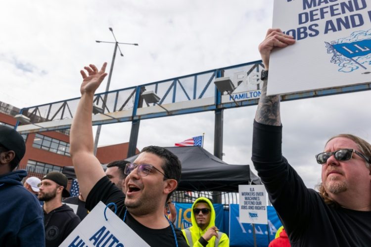 Striking workers at the Red Hook Container Terminal in Brooklyn, New York, gather after members of the International Longshoremen's Association began walking off the job. ©AFP