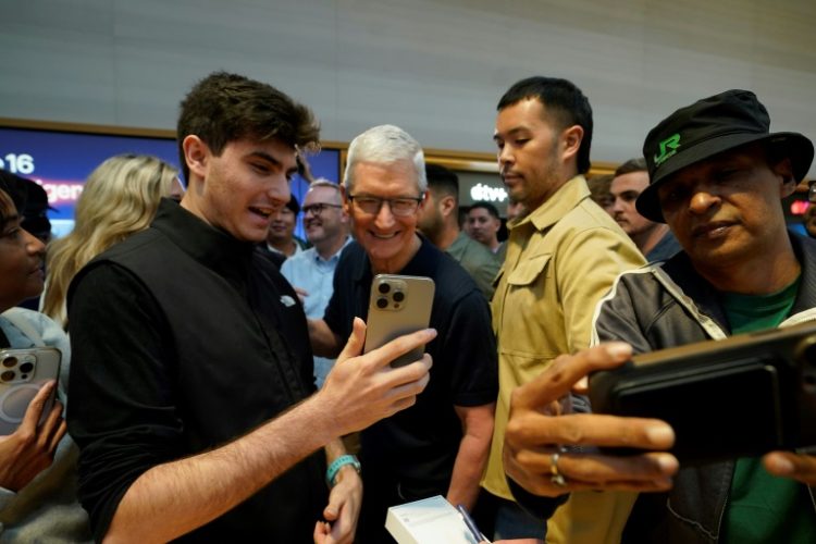 Apple CEO Tim Cook (C) joins customers during Apple's iPhone 16 launch in New York on September 20, 2024. ©AFP