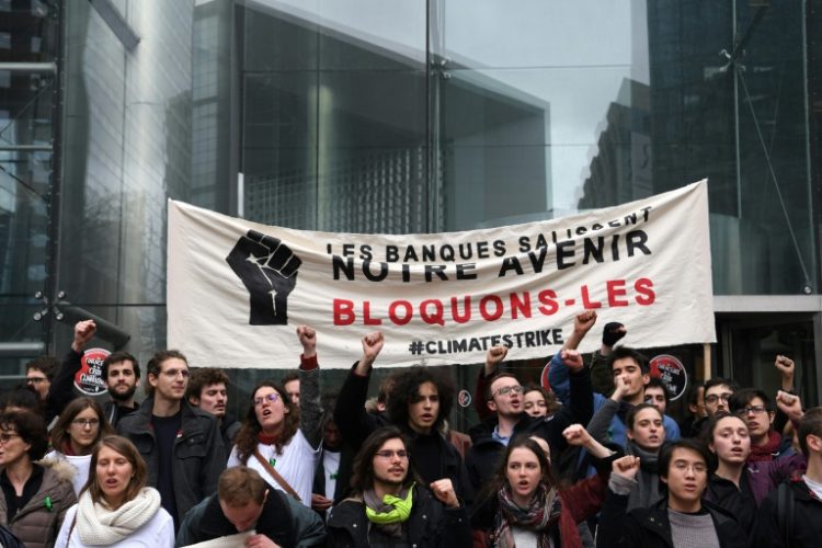 Climate activists held a banner reading 'Banks dirty our future. Let's block them' outside the headquarters of French bank Societe Generale in 2019. Protests are one of the risks bank face over their response to climate change. ©AFP