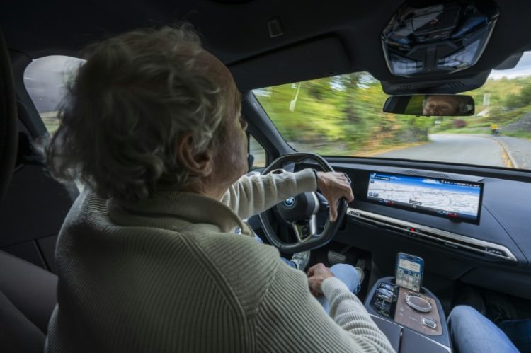 Baard Gundersen at the wheel of his electric BMW iX in Baerum, Oslo. ©AFP