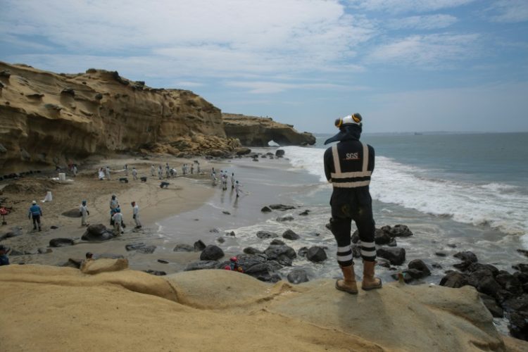 A picture released by the NGO Coast 2 Coast Movement shows workers cleaning up Peru's Las Capullanas beach after an oil spill. ©AFP