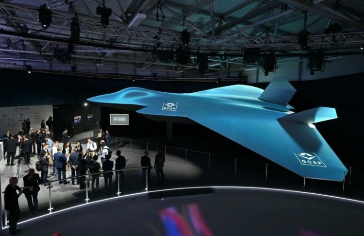 Delegates look at the Global Combat Air Programme (GCAP) 6th generation fighter jet concept design at the Farnborough International Airshow 2024. ©AFP