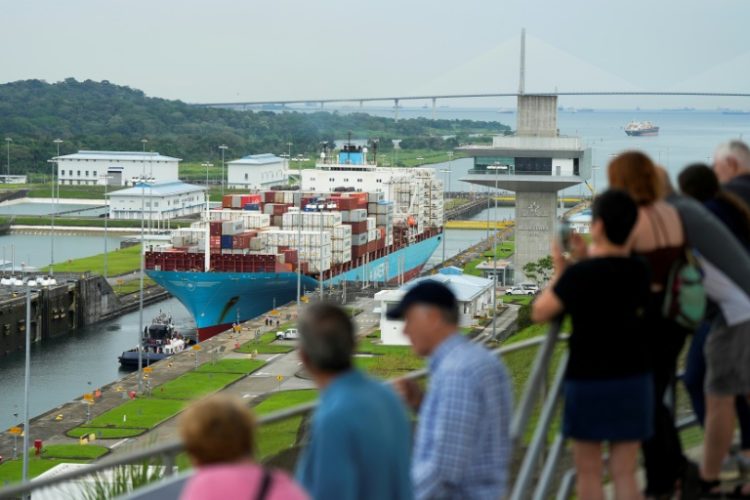 Tourists watch a Danish-flagged cargo ship passing through the Panama Canal. ©AFP