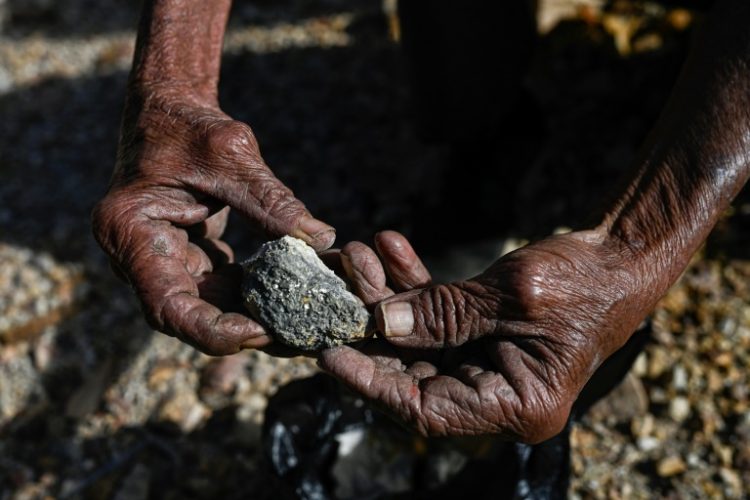 An artisanal miner holds ore extracted from the abandoned San Sebastian mine in Santa Rosa de Lima, La Union department, El Salvador, on December 5, 2024. ©AFP