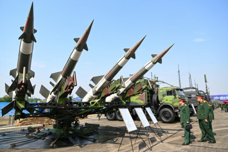 Vietnamese military officials look at an anti-aircraft missile launcher and ammunition during a defence expo in Hanoi. ©AFP