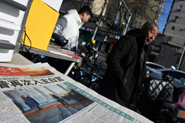 A newspaper featuring an image of Donald Trump arriving at the White House ahead of his inauguration as US President is seen at a news stand in Beijing on January 21. ©AFP