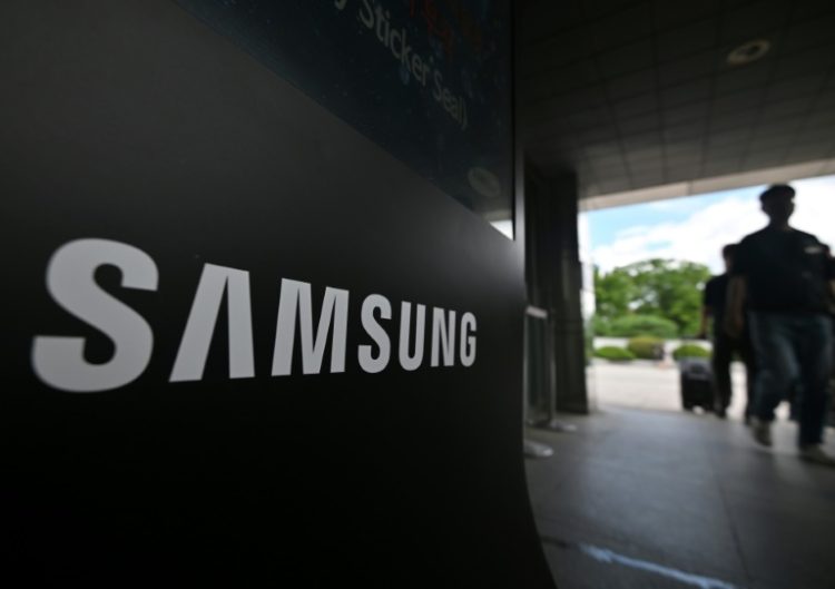 Members of the National Samsung Electronics Union walk past a Samsung logo outside the company's Giheung Campus in Yongin on July 10, 2024. ©AFP