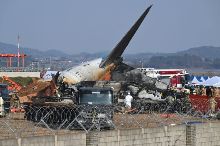 Rescue personnel work near the wreckage of a Jeju Air plane after it crashed at South Korea's Muan International Airport this week, killing 179 people on board. ©AFP