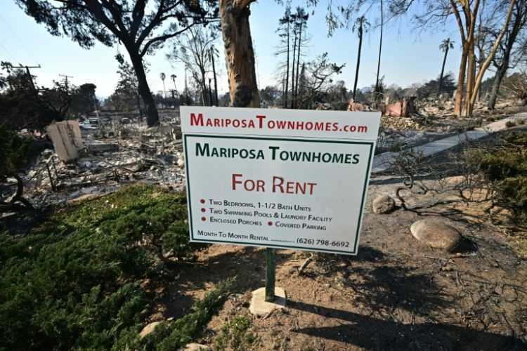 The remains of townhomes destroyed by the Eaton Fire lie behind an advertising sign in Altadena, California. ©AFP