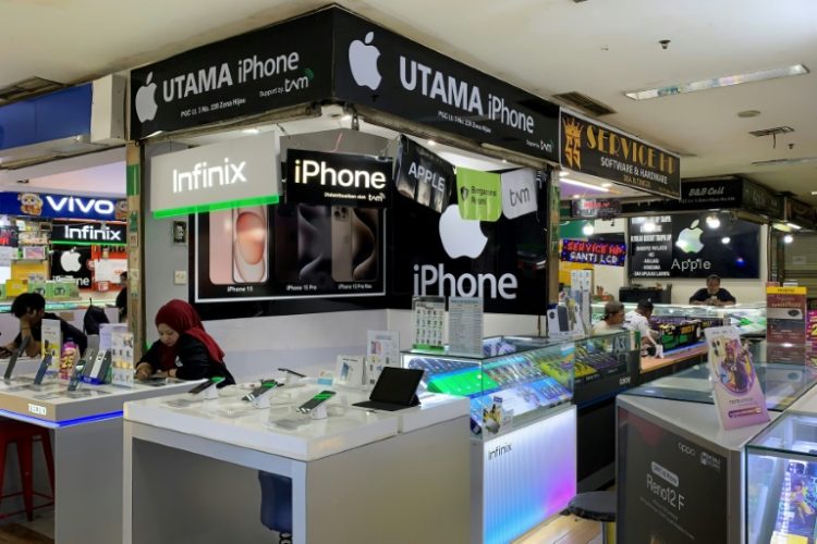 Vendors wait for customers at a mobile phone shopping centre in Jakarta. ©AFP