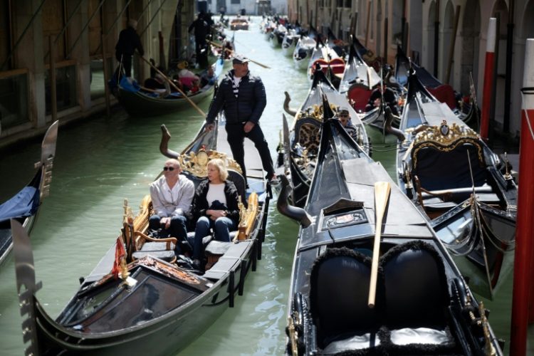 A gondolier with two customers near San Marco Square in Venice on April 25, 2024. ©AFP