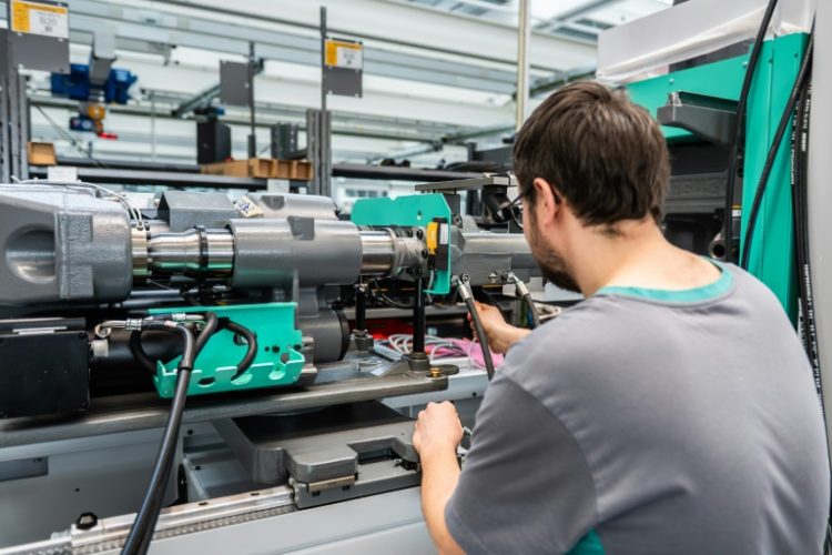 An employee works on a machine at the Arburg plant. ©AFP