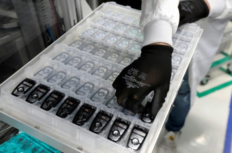 A worker assembles electronic car keys at a manufacturing plant in Mexico. ©AFP