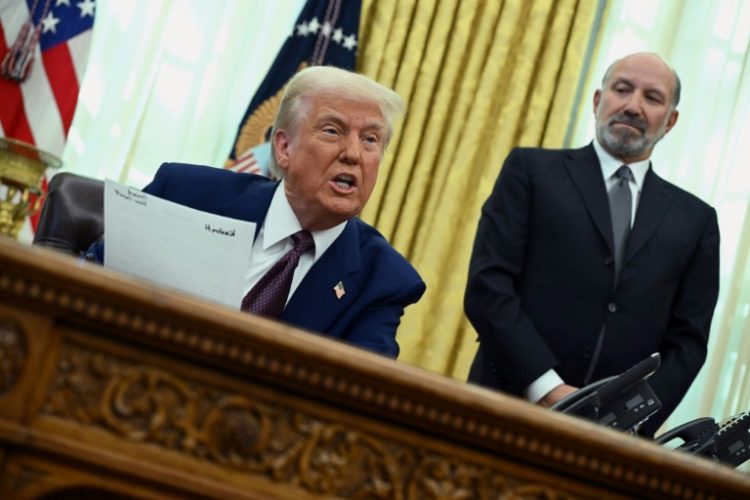 US President Donald Trump announces reciprocal tariffs from the White House Oval Office on February 13, 2025 as Howard Lutnick looks on. ©AFP